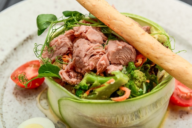 Insalata fresca di tonno, cetriolo, uova di quaglia e verdure su fondo nero