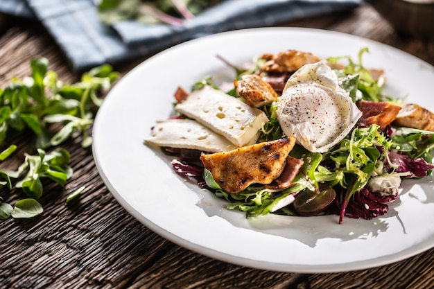 Insalata fresca e gustosa con insalata mista servita con formaggio di pecora, carne di pollo alla griglia e uova condite.