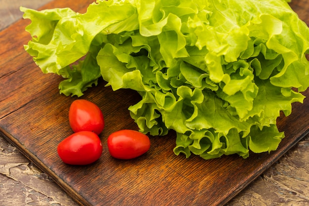 Insalata fresca e pomodorini rossi su un tagliere. Alimenti dietetici con vitamine