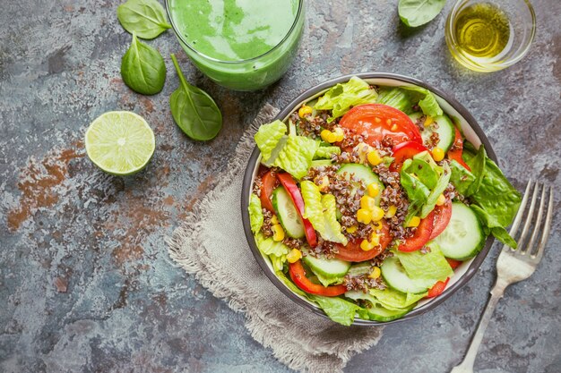 Insalata fresca e sana con quinoa, pomodori rossi, peperoni dolci, cetrioli, mais e avocado su fondo di pietra, vista dall'alto. Cibo salutare. Pasto super.