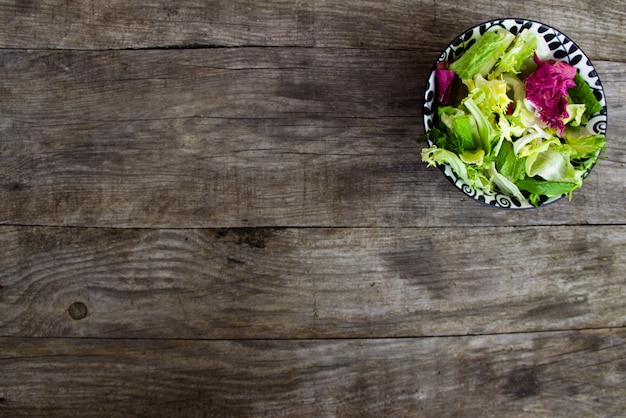 Insalata fresca in zolla sulla tabella di legno. Spazio copia gratuita.