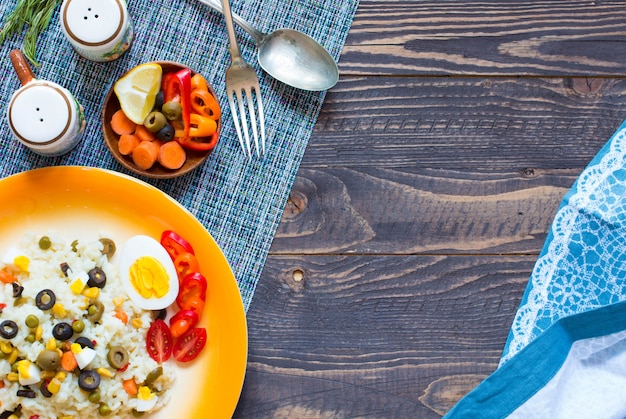 Insalata fresca vegetariana con riso bianco su fondo di legno