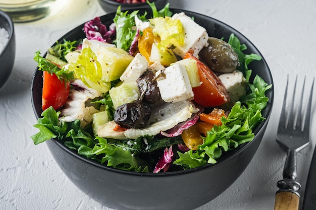 Insalata greca con formaggio feta e olive fresche biologiche, su sfondo bianco