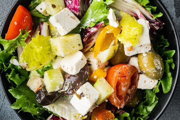 Insalata greca con formaggio feta e olive fresche biologiche, sul tavolo grigio, vista dall'alto laici piatta