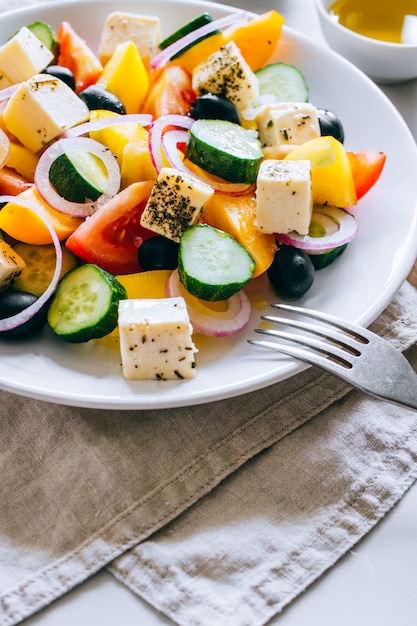 Insalata greca con olio d&#39;oliva su marmo.