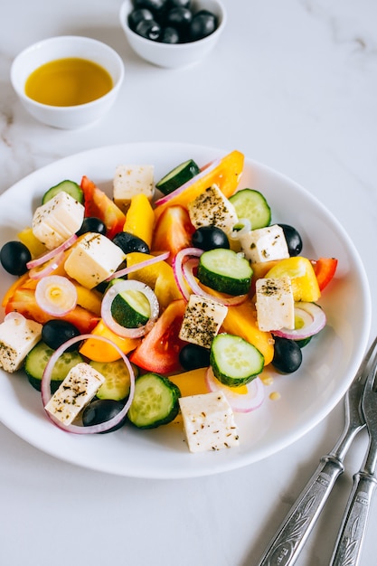 Insalata greca con olio d&#39;oliva su marmo.