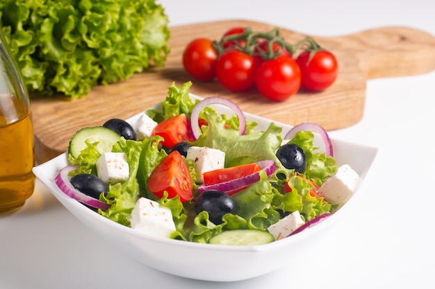 Insalata greca con pomodori freschi, cetrioli, olive, feta e cipolla rossa. Cibo sano e dietetico