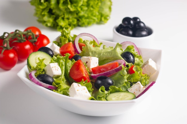 Insalata greca con pomodori freschi, cetriolo, olive, formaggio feta e cipolla rossa Concetto di cibo sano e dietetico