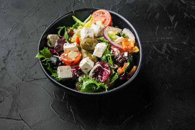 Insalata greca con verdure fresche, feta e olive kalamati, su nero