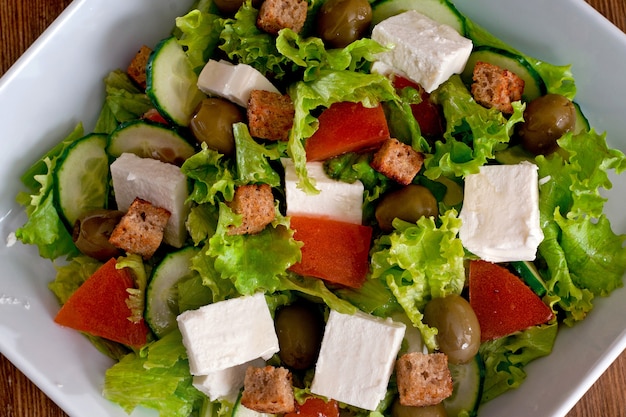 Insalata greca con verdure fresche, formaggio feta, olive nere e pane