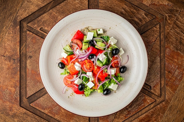 Insalata greca di verdure fresche, pomodori, cetrioli, cipolla, peperoncino, lattuga, olive nere, feta, olio d'oliva