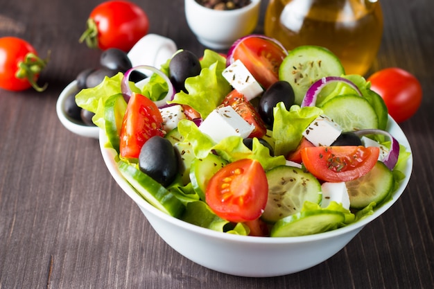 Insalata greca fresca su fondo di legno.