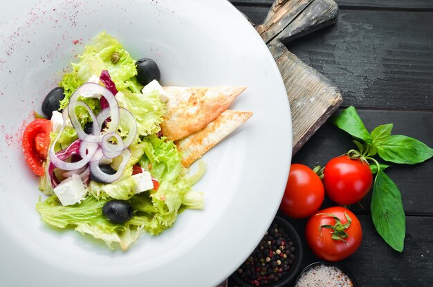 Insalata greca Insalata di verdure con feta olive e pomodorini Nel piatto Vista dall'alto Spazio libero per il testo Stile rustico