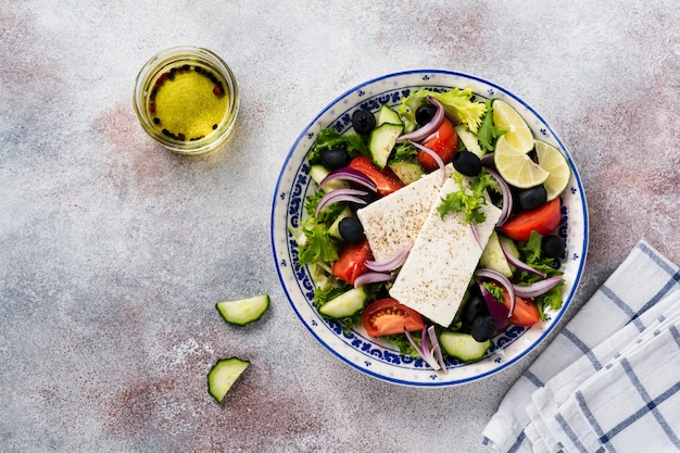 Insalata Greca Tradizionale. Piatto vegetariano con lattuga fresca, olive, peperoni, cetrioli, cipolle e formaggio feta. Vista dall'alto.