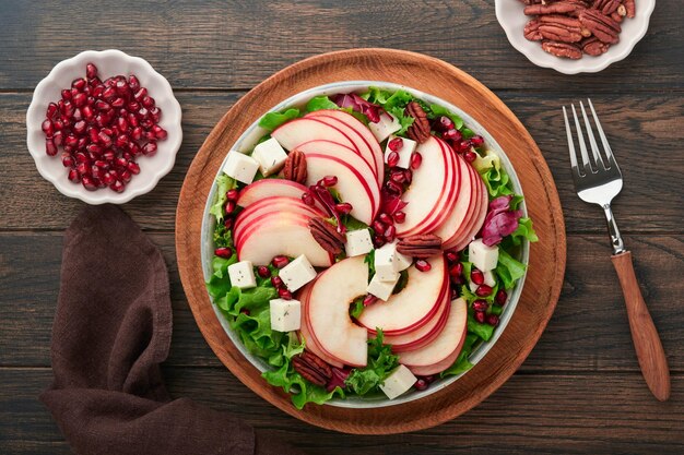 Insalata Insalata verde di frutta fresca con formaggio feta mela melograno pecan e lattuga su piatto bianco Idea per un'insalata di Natale invernale sana e deliziosa Mangiare sano ed equilibrato Vista dall'alto