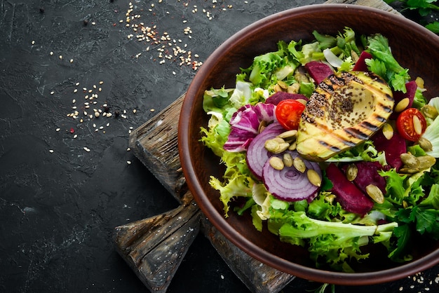 Insalata Lattuga barbabietole avocado e semi di zucca Vista dall'alto su sfondo nero Spazio libero per la copia