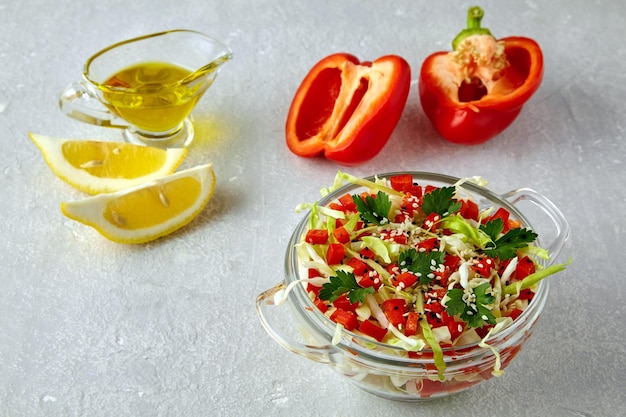 Insalata leggera estiva di paprika di cavolo bianco fresco e prezzemolo condito con olio e limone in un bicchiere