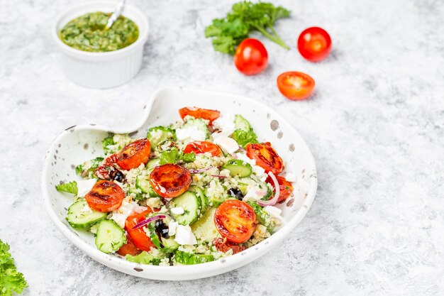 Insalata mediterranea di cuscus con pomodorini fritti, cetriolo e salsa al pesto