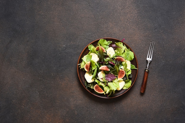 Insalata mista con fichi e brie su fondo di cemento