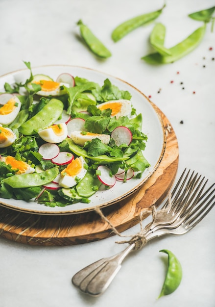 Insalata primaverile con ravanello, uova sode, rucola, piselli e menta