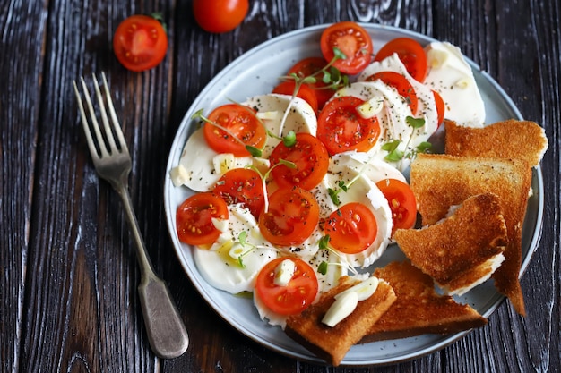 Insalata sana con mozzarella e pomodorini su un piatto Alimenti dietetici Una corretta alimentazione Cibo italiano