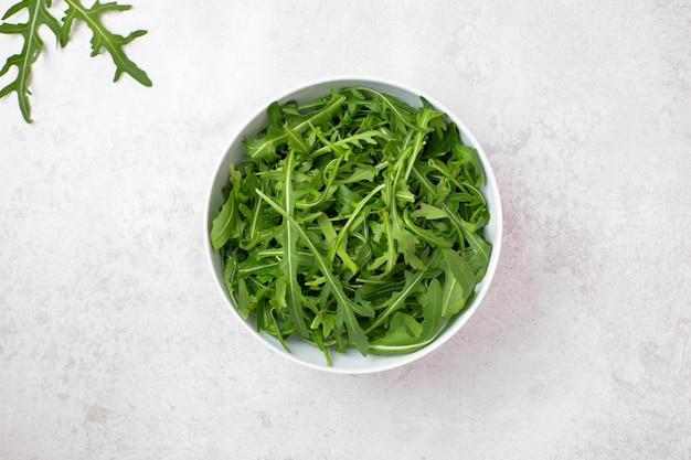 Insalata sana e fresca con rucola in una tazza bianca