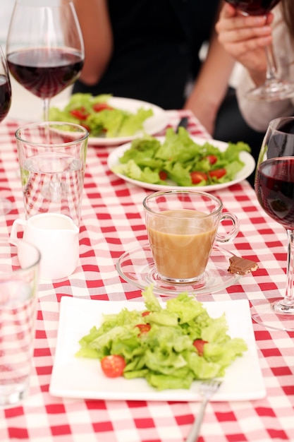 Insalata sana e vino rosso in un ristorante su una tovaglia quadrata