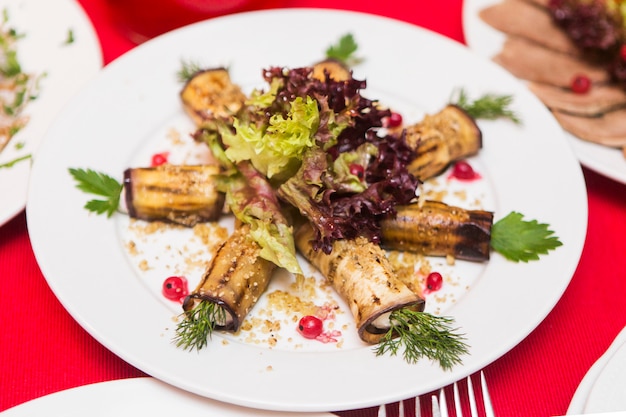 Insalata saporita sul piatto bianco sulla tavola festiva nel ristorante