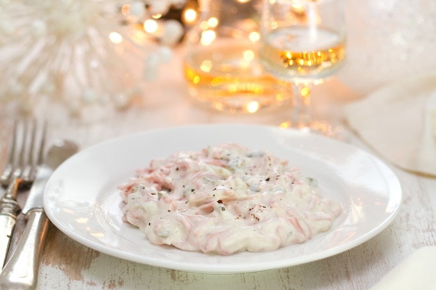 Insalata sul piatto bianco su legno bianco