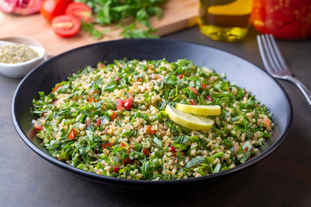 Insalata tradizionale libanese tabouli tabule con quinoa, erbe aromatiche, pomodori, menta e limone.