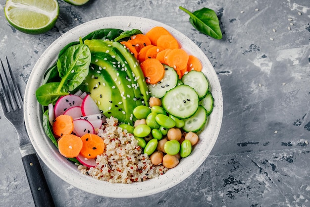 Insalata vegana Buddha bowl con spinaci quinoa ceci arrostiti pollo alla griglia avocado fagioli edamame cetrioli sesamo e semi di zucca