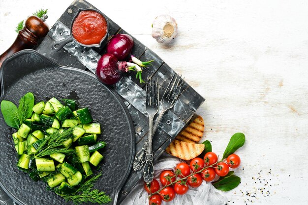 Insalata vegana con cetriolo e aneto su un piatto nero Stile rustico Vista dall'alto Spazio libero per il testo