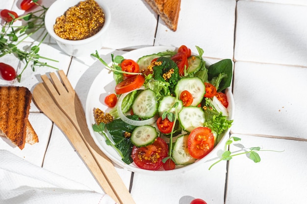 Insalata vegetariana con pomodoro cetriolo e spinaci in un piatto