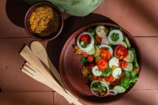 Insalata vegetariana con pomodoro cetriolo e spinaci in un piatto