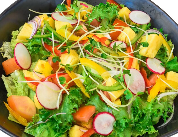 Insalata vegetariana con ravanello rucola ananas e pomodori isolati su sfondo bianco