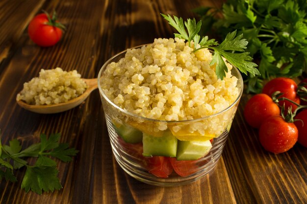 Insalata vegetariana con verdure e quinoa sul legno marrone