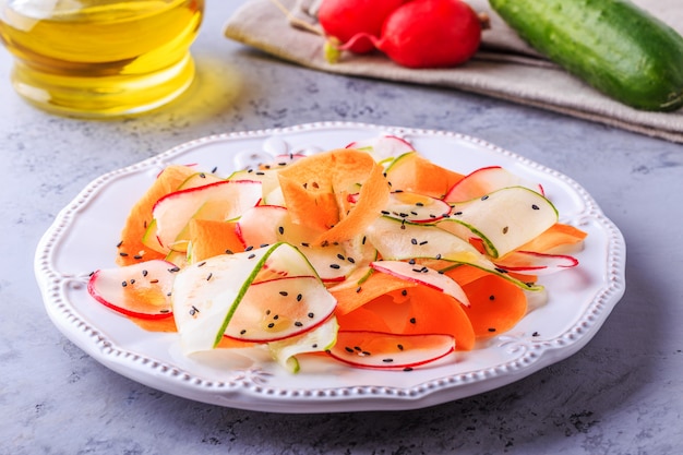 Insalata vegetariana di carota, cetriolo e ravanello.