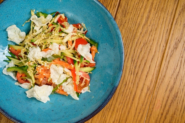 Insalata vegetariana di verdure con pomodori, peperoni e cipolle sulla tavola di legno Insalata sana con verdure fresche estive mature