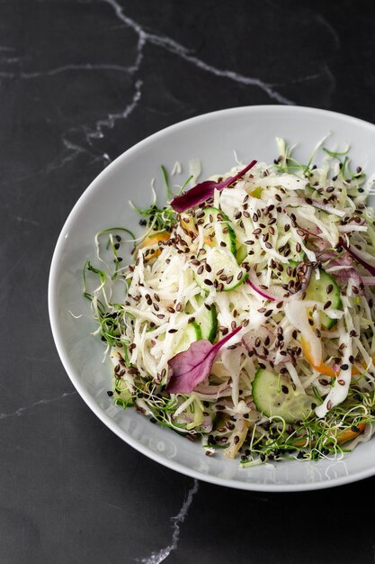 Insalata vegetariana Insalata vegana primaverile con cavolo cetriolo cipolla verde e prezzemolo Vista dall'alto piatto a testa in giù