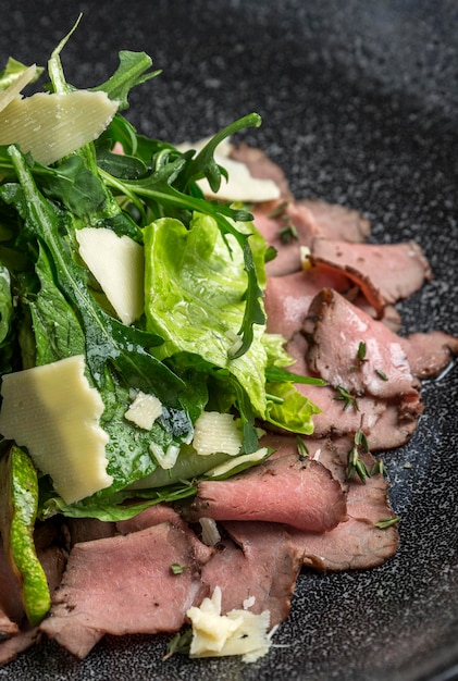 Insalata verde appetitosa con roast beef e parmigiano Una corretta alimentazione sana Closeup verticale