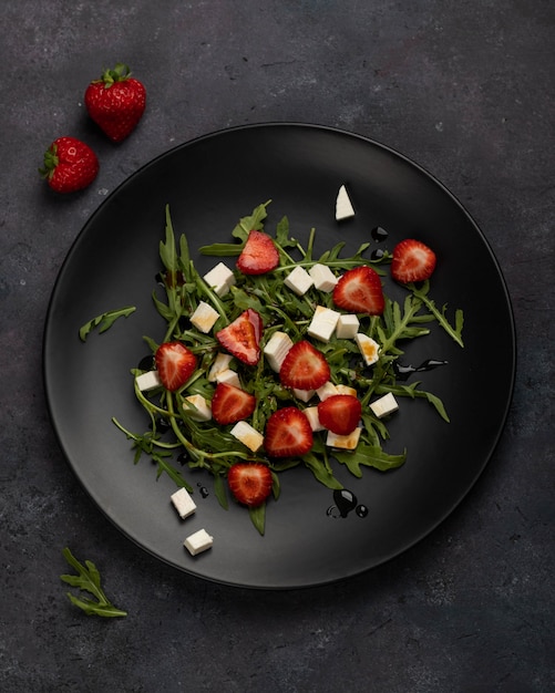 Insalata verde con fragole, camembert, rucola sulla banda nera