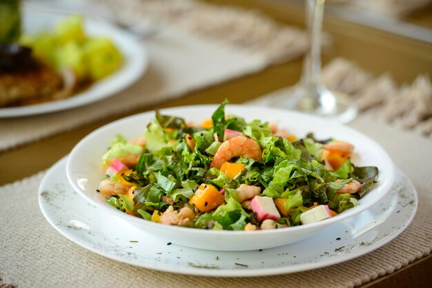 Insalata verde con gamberetti e kani e frutti tropicali Cibo sano