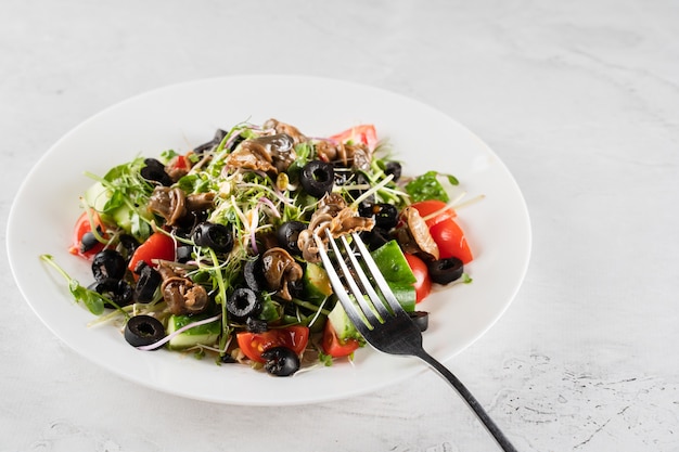 Insalata verde con lumache d'uva lumache su sfondo bianco. Cucina gourmet francese.