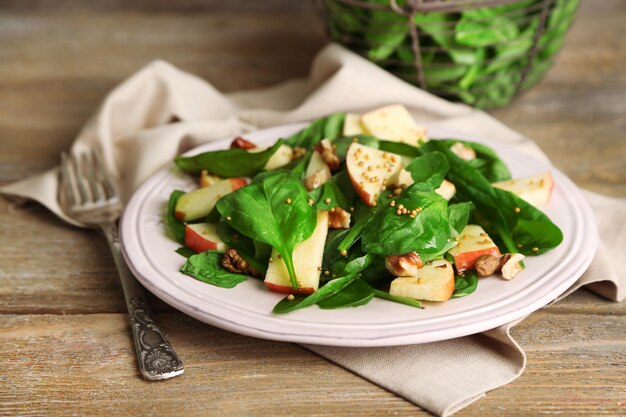 Insalata verde con mele noci e formaggio su fondo di legno