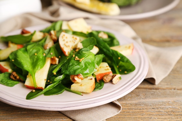 Insalata verde con mele noci e formaggio su fondo di legno