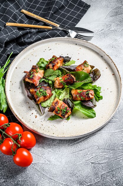 Insalata verde con petto di pollo al forno avvolto in pancetta di maiale.