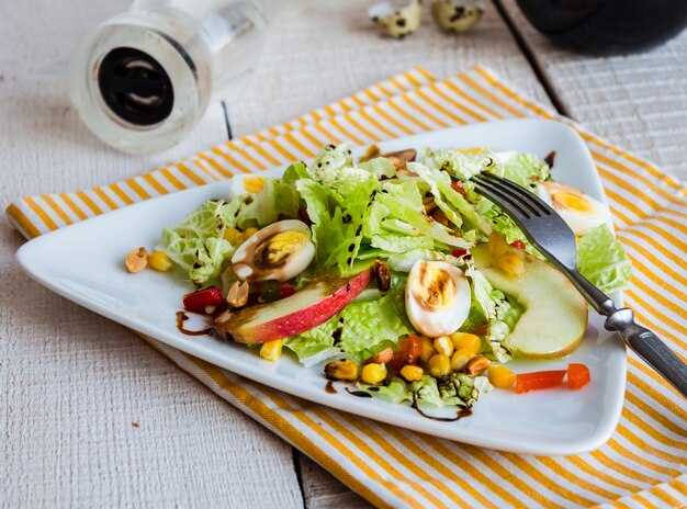 Insalata verde con uova di quaglia, mais e mela dolce, spuntino, cibo sano