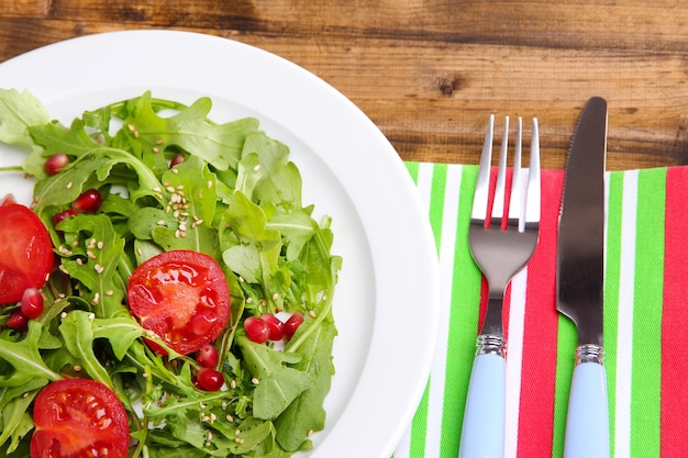 Insalata verde fatta con rucola e sesamo su piastra su fondo di legno