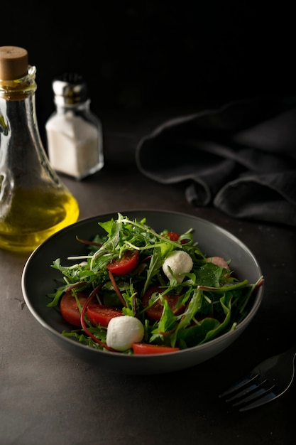 Insalata verde fresca con foglie di lattuga e rucola con pomodorini e mozzarella