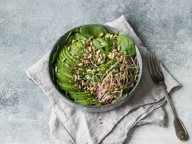 Insalata verde sana di spinaci, germogli, avocado e semi vari